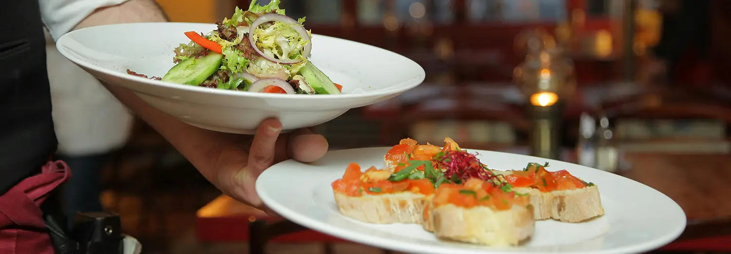 food photography of plated salad and bruschetta served at restaurant