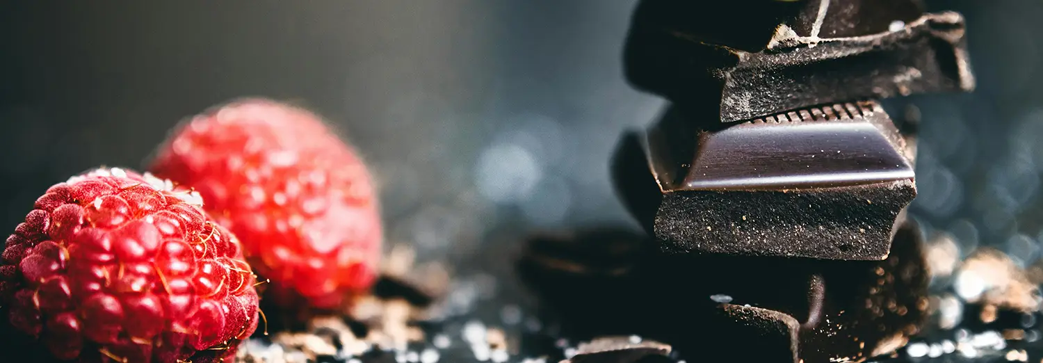 macro food photography of coffee beans and fresh raspberry