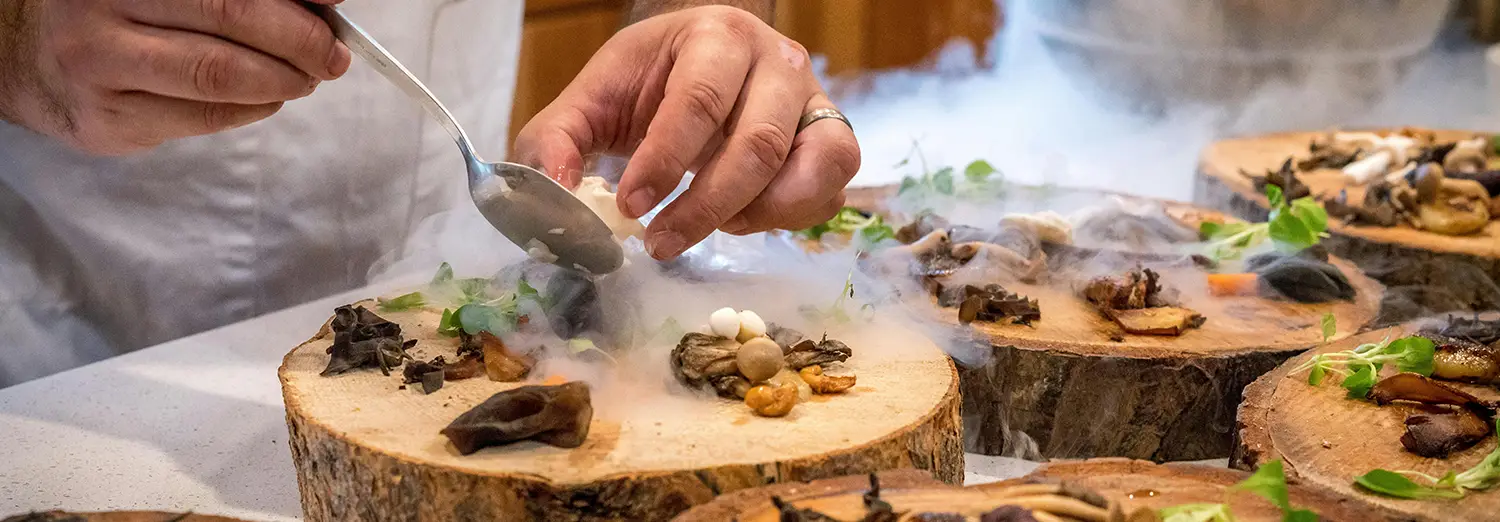 food photography of chef plating gourmet dish with smoke effect