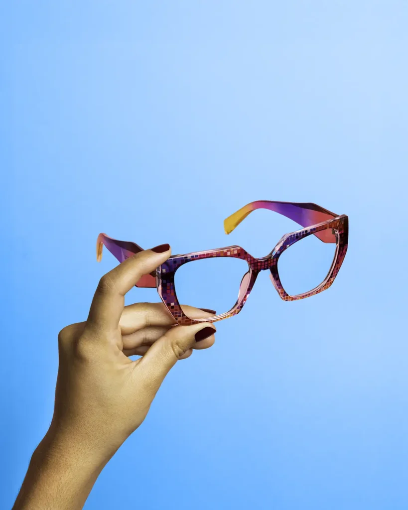 Product photography of pink and blue glasses held by hand